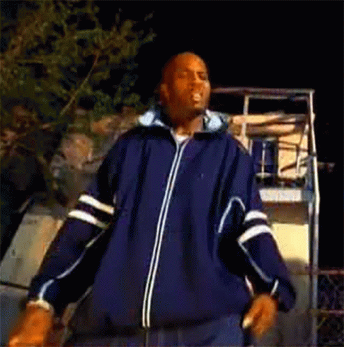 A Man In A Blue Jacket Is Dancing In Front Of A Basketball Hoop . GIF