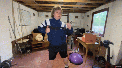 A Man In A Blue Jacket Is Giving A Thumbs Up In A Gym With A Box That Says Ebay On It GIF