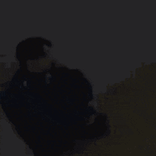 A Man In A Blue Jacket Is Sitting On The Floor In A Room . GIF