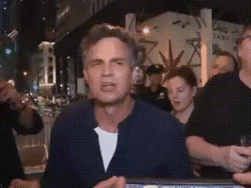 A Man In A Blue Jacket Is Standing In Front Of A Group Of People . GIF