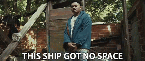 A Man In A Blue Jacket Stands In Front Of A Brick Wall With The Words This Ship Got No Space Below Him GIF