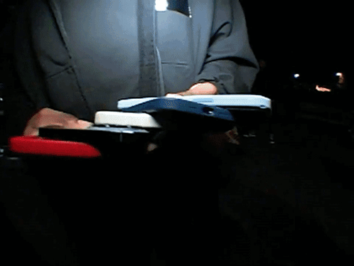 A Man In A Blue Jacket Stands In Front Of A Stadium GIF