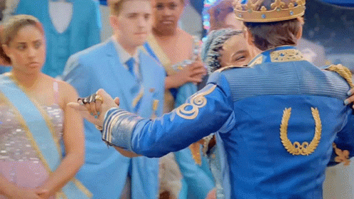 A Man In A Blue Jacket With A Horseshoe On The Back Is Holding A Woman 'S Hand GIF