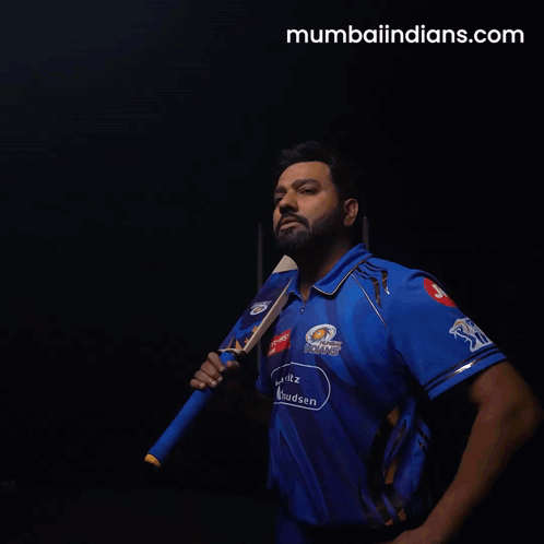 A Man In A Blue Mumbai Indians Shirt Holds A Cricket Bat GIF