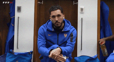 A Man In A Blue Nike Jacket Sits In A Changing Room GIF