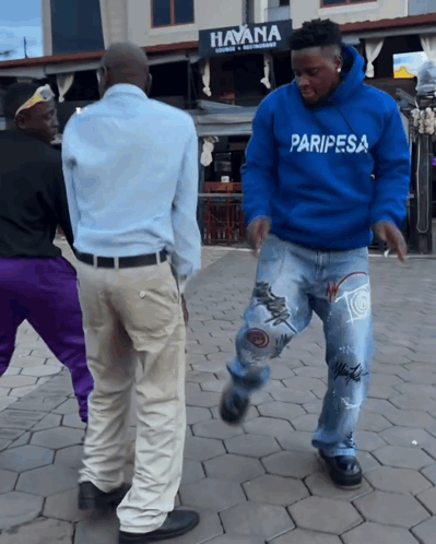 a man in a blue paripesa sweatshirt dancing