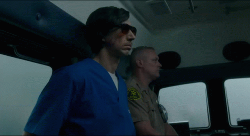 A Man In A Blue Scrub Is Standing Next To A Man In A Tan Uniform With A Badge That Says Sheriff GIF