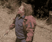 A Man In A Blue Shirt And A Red Jacket Is Holding A Knife GIF