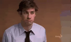 A Man In A Blue Shirt And Black Tie Is Making A Face . GIF