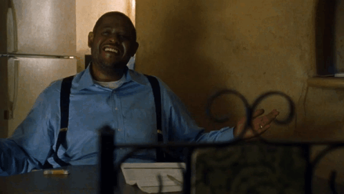 A Man In A Blue Shirt And Suspenders Is Smiling GIF