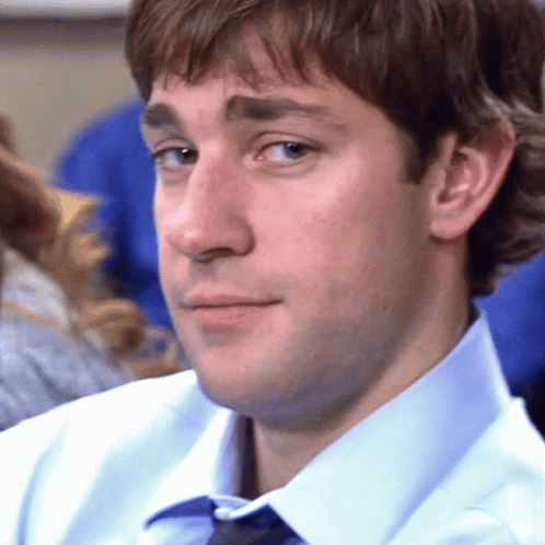 A Man In A Blue Shirt And Tie Is Looking At The Camera GIF