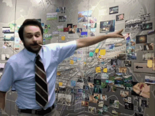 A Man In A Blue Shirt And Tie Is Pointing At A Map Of A City GIF