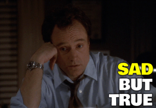 A Man In A Blue Shirt And Tie Is Sitting At A Desk With The Words Sad But True Above Him GIF