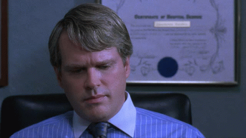 Man In Blue Shirt And Tie In Front Of Certificate GIF