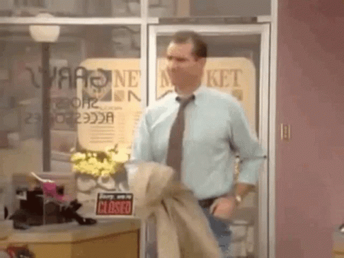 Man In Blue Shirt And Tie In Front Of Closed Store GIF