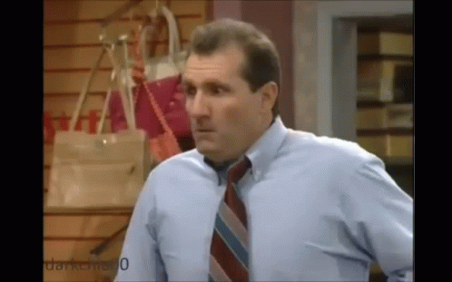 Man In Blue Shirt And Tie In Front Of Handbag Wall GIF