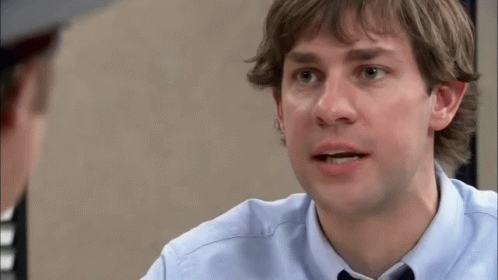 A Man In A Blue Shirt And Tie Is Talking To Another Man In A Hat . GIF