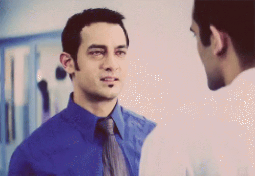 A Man In A Blue Shirt And Tie Is Talking To Another Man GIF