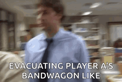 A Man In A Blue Shirt And Tie Is Walking In An Office And Says Evacuating Player A 'S Bandwagon Like GIF