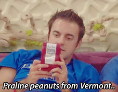 A Man In A Blue Shirt Holds A Bag Of Praline Peanuts From Vermont GIF