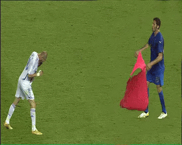 A Man In A Blue Shirt Holds A Red Cloth Over A Man In A White Shirt GIF