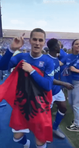 a man in a blue shirt holds a red flag