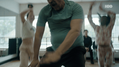 A Man In A Blue Shirt Is Dancing In A Room With A Hbo Logo On The Bottom GIF