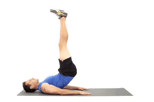 A Man In A Blue Shirt Is Doing A Leg Lift Exercise On A Yoga Mat GIF