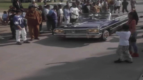 A Man In A Blue Shirt Is Driving A Blue Car GIF