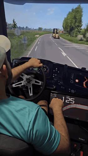A Man In A Blue Shirt Is Driving A Truck With The Number 125 Displayed On The Dashboard GIF