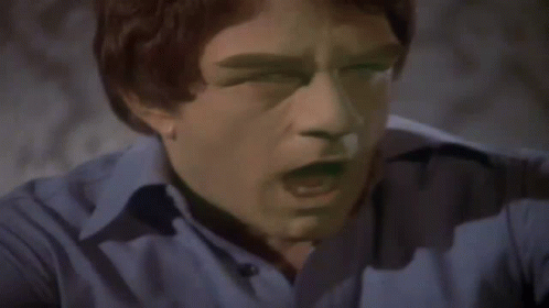 A Man In A Blue Shirt Is Flexing His Arm Muscles GIF