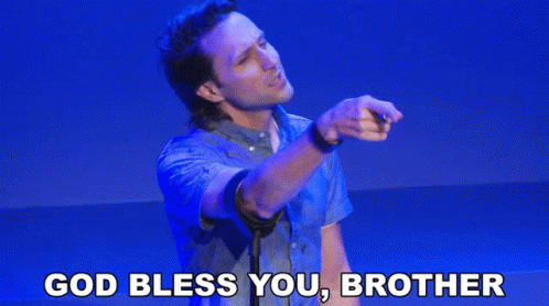 A Man In A Blue Shirt Is Giving A Speech With The Words God Bless You Brother Above Him GIF