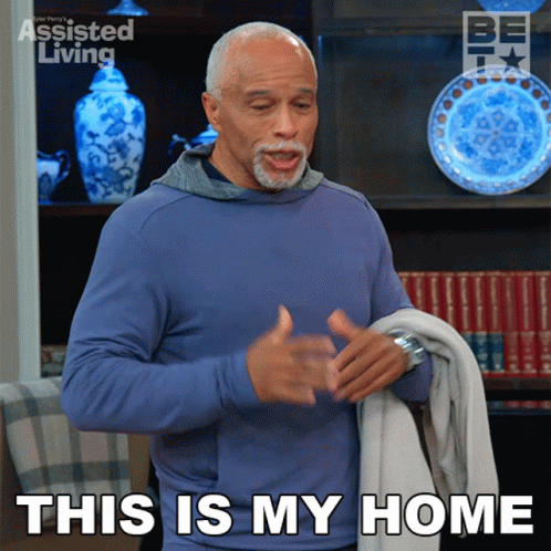 a man in a blue shirt is holding a blanket and says this is my home