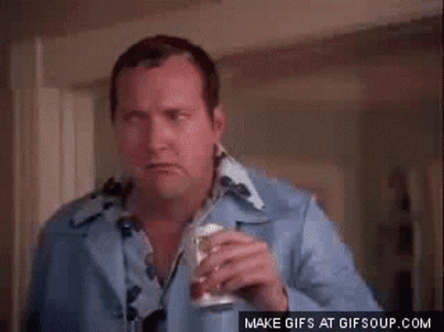 A Man In A Blue Shirt Is Holding A Can Of Soda GIF