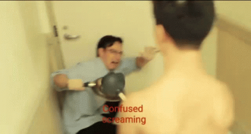 A Man In A Blue Shirt Is Holding A Hair Dryer While Another Man Is Screaming Behind Him GIF