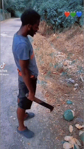 A Man In A Blue Shirt Is Holding A Large Axe In His Hand GIF