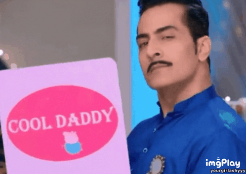 A Man In A Blue Shirt Is Holding A Pink Card That Says Cool Daddy GIF