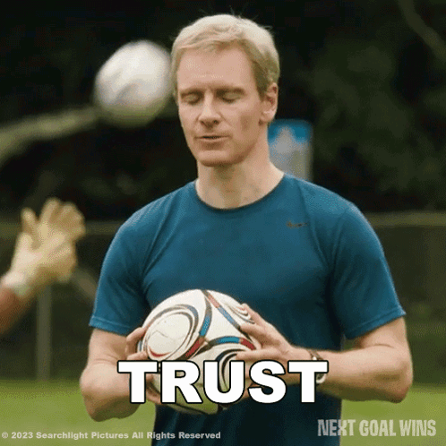A Man In A Blue Shirt Is Holding A Soccer Ball And The Word Trust Is Above Him GIF