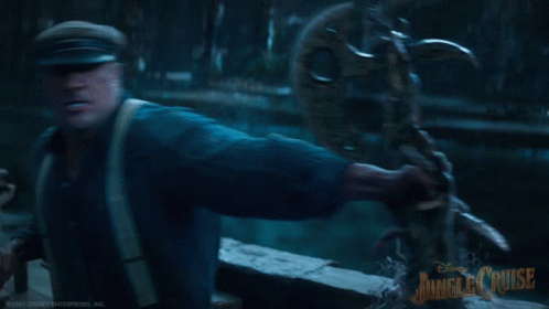 A Man In A Blue Shirt Is Holding A Statue With Jungle Cruise Written On The Bottom Right GIF