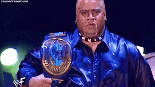 A Man In A Blue Shirt Is Holding A World Heavyweight Championship . GIF