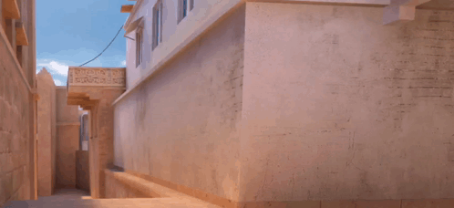 A Man In A Blue Shirt Is Jumping In The Air In Front Of A Building With A Sign That Says ' Ambulance ' GIF