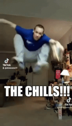 A Man In A Blue Shirt Is Jumping In The Air With The Caption The Chills GIF