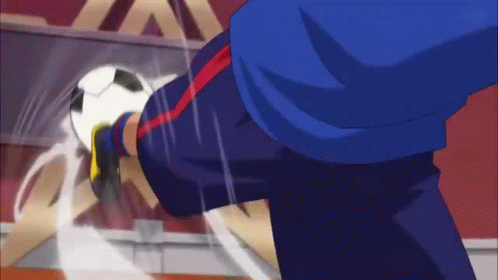 A Man In A Blue Shirt Is Kicking A White Ball GIF