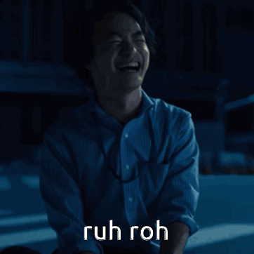 A Man In A Blue Shirt Is Laughing With The Words Ruh Roh Written Above Him GIF