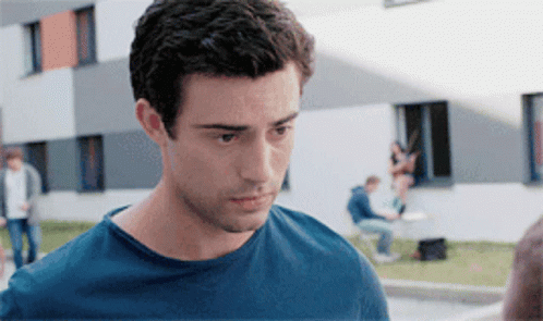 a man in a blue shirt is looking at something
