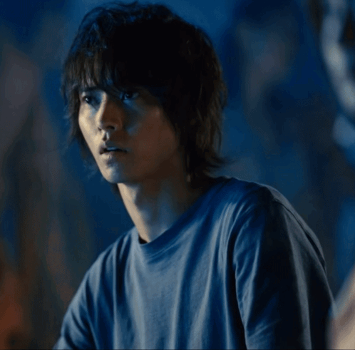 A Man In A Blue Shirt Is Looking To The Side GIF