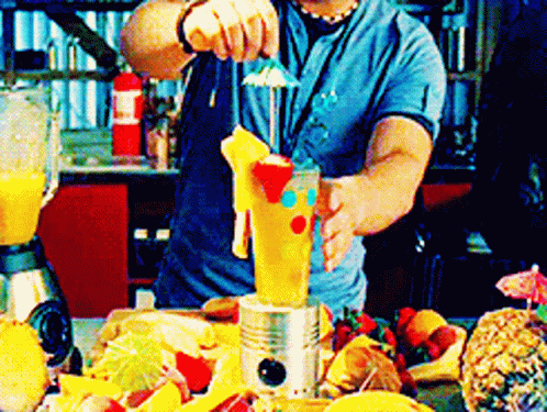 A Man In A Blue Shirt Is Making A Drink With A Blender GIF