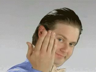 A Man In A Blue Shirt Is Making A Funny Face With His Hands GIF