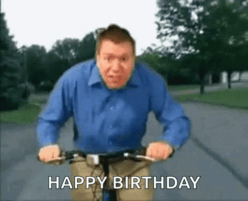 A Man In A Blue Shirt Is Riding A Bike With The Words Happy Birthday Written Below Him GIF