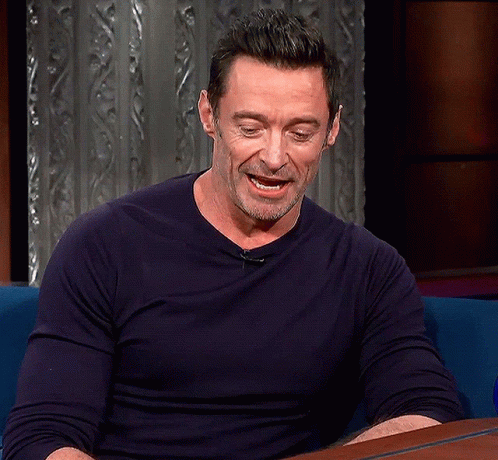 A Man In A Blue Shirt Is Sitting At A Table GIF